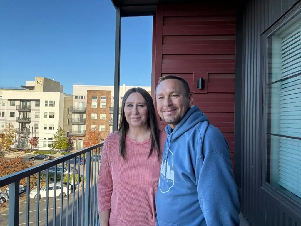 Will and Missy Faulkenberry standing outside on the balcony of an apartment