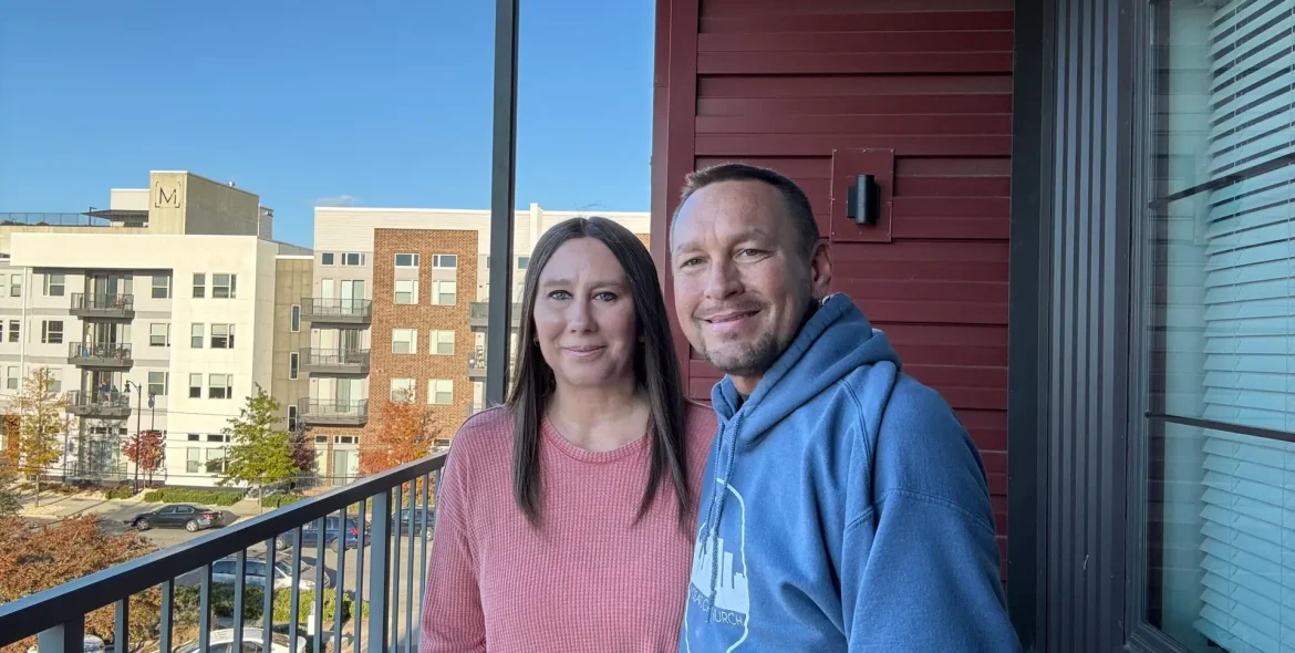 Will and Missy Faulkenberry standing outside on the balcony of an apartment